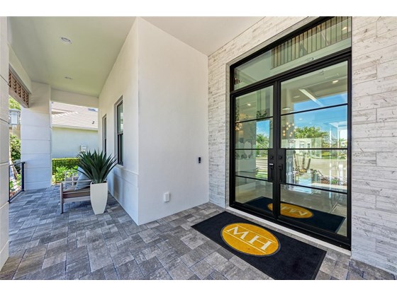 Stone trim surrounds the Impact Glass and iron double entry doors. Plenty of room to sit and relax on the front porch. - Single Family Home for sale at 602 Regatta Way, Bradenton, FL 34208 - MLS Number is A4499642